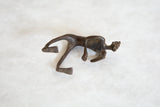 Side view of the vintage African bronze man's abstract crawling form and dark patina.