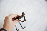 Handmade African bronze figurine held in hand to demonstrate its small scale.
