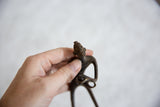 The vintage African bronze man's stylized head and shoulders held in hand for scale.