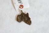 Handmade bronze African continent pendant showing its unique aged patina.