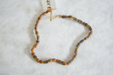 Close-up of vintage African flour beads, showing earthy stripes and natural straw stringing.