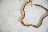 Textured vintage African flour beads with diverse patterns and knotted straw-like stringing.
