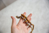 Vintage African flour beads, showing texture, yellow-orange, blue-grey hues, and straw stringing.