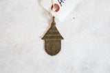 Vintage African bronze spotted hut pendant, showing textured roof and top loop.