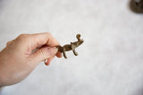 Vintage bronze elephant pendant held in hand to show its petite scale.