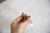 Vintage African bronze elephant pendant held to show its handmade texture and scale.