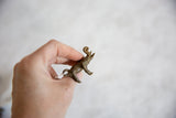A hand holds the vintage African bronze elephant pendant, showcasing its profile and scale.