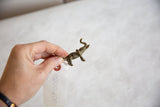 Vintage African bronze elephant pendant held to demonstrate its scale.
