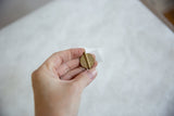 The textured concentric circle pattern on a vintage African Baule bead held in hand.