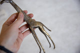 Vintage African giraffe sculpture held by hand, showcasing dark bronze and golden streaks.
