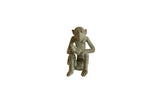 Vintage African oxidized bronze sitting monkey sculpture holding a banana.