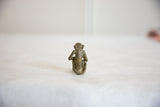Vintage African handmade bronze monkey, back view with textured patina.
