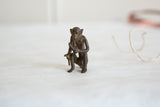 Vintage African bronze monkey close-up, showing detailed face, hands holding banana.