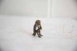 Side profile of a textured African bronze monkey, showing its rustic, handmade detail.