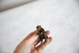 Vintage African bronze monkey eating two bananas, held in hand.