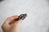 Textured surface and dark, aged finish of vintage African bronze monkey.