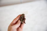 Vintage African bronze monkey figurine held in hand to show its small scale.