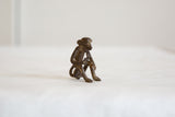 Vintage African bronze monkey sculpture from a low angle, highlighting its aged texture.