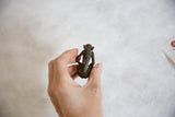 Collectible vintage handmade African bronze sitting monkey, rear view, aged patina.