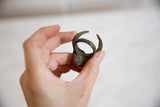 Vintage African bronze horned mask ring, highlighting its textured surface and elegant curves.