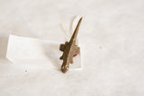 The elongated shape and textured bronze finish of an African lizard ring.