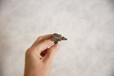 Side view of the vintage bronze lizard ring showing its textured band and aged patina.