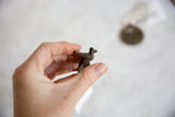 Hand-cast vintage African bronze bird ring held for scale.