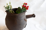 Antique African pitcher highlighting its side handle and incised textural patterns.