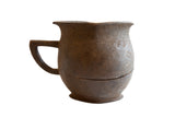 Antique African wooden pitcher with a bulbous body and dark, rustic patina.