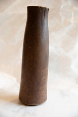 Angled profile of the antique wooden vase, highlighting its aged surface and a crack along the rim.