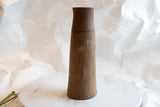 Natural wood grain and aged texture on the upper part of the antique African vase.