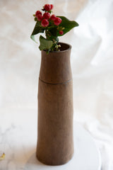 Dark wood grain with aged character and horizontal groove on antique African vase.