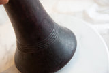 Detail of antique African wooden vase, highlighting dark wood texture and carved bands.