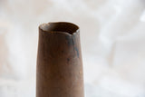 Antique African wooden vase with chipped rim, visible vertical crack, and aged wood.