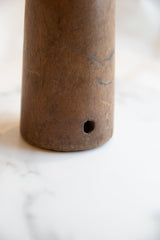 Antique African wooden vase displaying aged wood texture, dark grain, and circular hole.