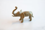 Collector's African bronze elephant sculpture, side profile, with trunk raised and golden patina.