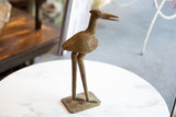Vintage African bronze stork head, detailed eye, and textured surface.