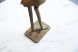 Vintage African bronze stork base with etched texture and greenish patina.
