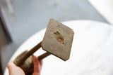 Underside detail of the vintage bronze stork's base, revealing aged texture and wear.