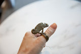 Vintage bronze chameleon ring with a textured body, shown worn on a thumb.
