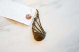 Vintage African bronze musical instrument showing its handmade charm and tag.
