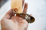 Vintage bronze musical instrument held in hand to show its petite scale.