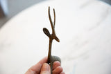 Vintage dark bronze gazelle's slender lower body and delicate legs, held by hand.