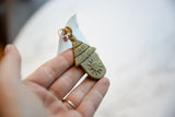 Handmade texture and embossed sun design on a vintage African bronze hut pendant.