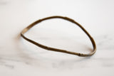 The unique, hand-formed shape and rustic texture of an antique bronze artifact.