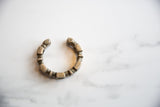 The handcrafted, segmented form of an antique African silver cuff with a time-softened patina.