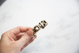Antique African silver bracelet held in hand to show scale and aged patina.