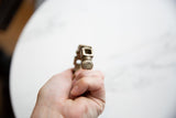Perspective view showing the handcrafted geometric end of an antique African bracelet.