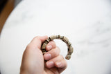 Antique African silver bracelet held in hand, showing its scale and aged patina.