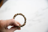 Antique African silver bracelet held in hand to show its geometric form and scale.